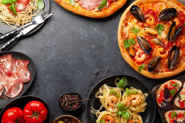Italian cuisine. Pasta, pizza, olives and antipasto toasts. Flat lay with copy space