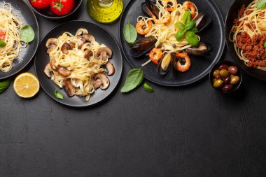 Çeşitli İtalyan makarnaları. Deniz ürünleri, mantar ve domates soslu makarna, spagetti bolonez. Üst görünüm düzlüğü kopyalama alanı ile yatıyordu