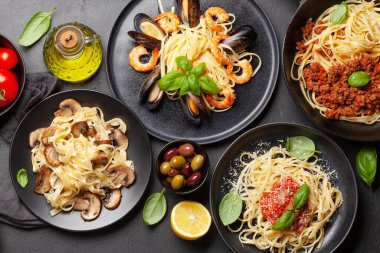 Çeşitli İtalyan makarnaları. Deniz ürünleri, mantar ve domates soslu makarna, spagetti bolonez. Üst görünüm düzlüğü