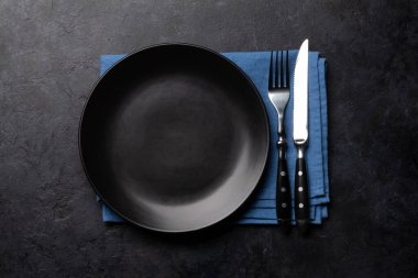 Boş tabak ve gümüş takımlar taş masaya. Üst görünüm düzlüğü kopyalama alanı ile yatıyordu. Yemek için şablon ya da maket