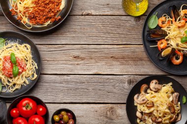 Çeşitli İtalyan makarnaları. Deniz ürünleri, mantar ve domates soslu makarna, spagetti bolonez. Üst görünüm düzlüğü kopyalama alanı ile yatıyordu