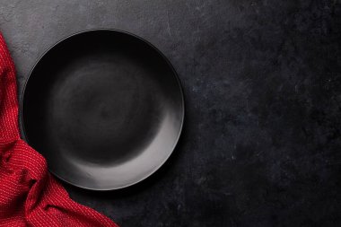 Boş tabak ve havlu taş masaya. Üst görünüm düzlüğü kopyalama alanı ile yatıyordu. Yemek için şablon ya da maket