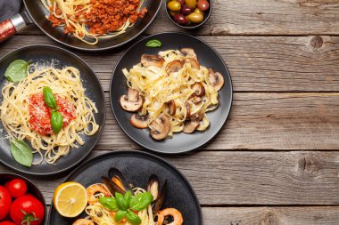 Çeşitli İtalyan makarnaları. Deniz ürünleri, mantar ve domates soslu makarna, spagetti bolonez. Üst görünüm düzlüğü kopyalama alanı ile yatıyordu