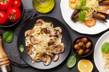 Çeşitli İtalyan makarnaları. Deniz ürünleri, mantar ve domates soslu makarna, spagetti bolonez. Üst görünüm düzlüğü