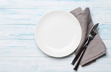 Boş tabak ve çatal bıçak takımı ahşap masada. Üst görünüm düzlüğü kopyalama alanı ile yatıyordu. Yemek için şablon ya da maket