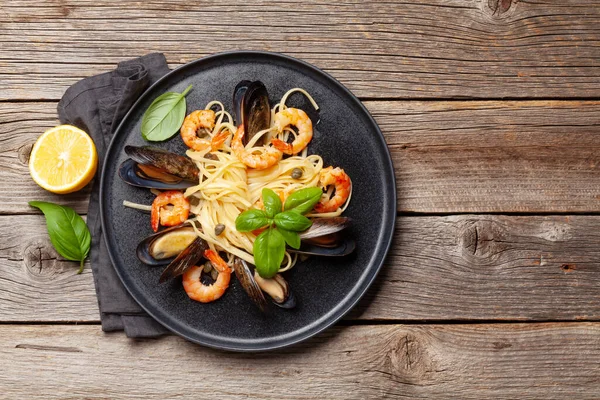 Seafood pasta with shrimps and mussels. Top view flat lay with copy space