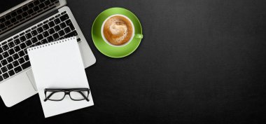 Deri masaya dizüstü bilgisayar, not defteri ve kahve. Kopyalama alanı olan düz