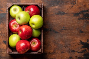 Ahşap kutuda kırmızı ve yeşil bahçe elmaları. Kopyalama alanı olan düz