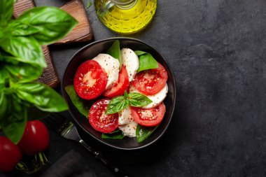 Taze domatesli Caprese salatası, fesleğen ve mozzarella peyniri. Üst görünüm düzlüğü kopyalama alanı ile yatıyordu