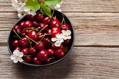 Kiraz çiçekleriyle dolu bir kasede olgunlaşmış kiraz. Üst görünüm düzlüğü kopyalama alanı ile yatıyordu