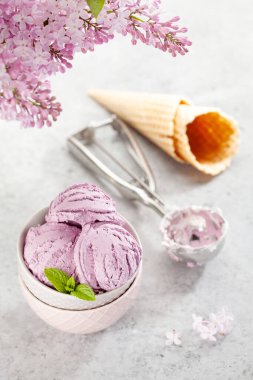 Meyveli dondurma, waffle külahı ve leylak çiçekleri.