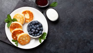 Böğürtlenli krep, ekşi krema ve böğürtlen. Üst görünüm düzlüğü kopyalama alanı ile yatıyordu