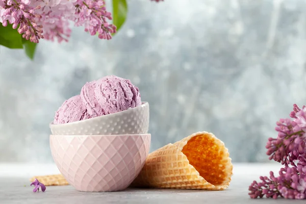ボウルにアイスクリームのサンデー ワッフルコーンとライラックの花 — ストック写真