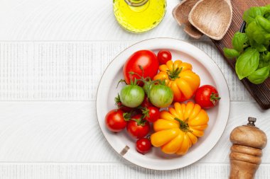 Çeşitli renkli bahçe domatesleri. Taze sebzeler ve baharatlar. Üst görünüm düzlüğü kopyalama alanı ile yatıyordu