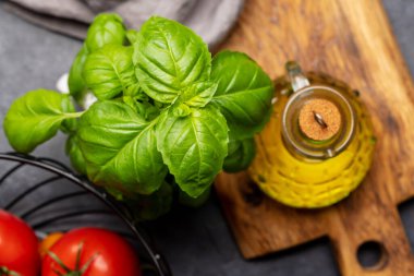 Yemek yapmak için gerekli malzemeler. İtalyan mutfağı. Domates, fesleğen ve zeytinyağı. Düz yatıyordu