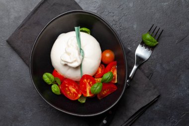 Burrata peyniri, çeşitli domatesler ve zeytinler. İtalyan mutfağı. Düz yatıyordu