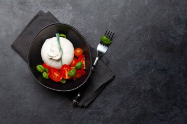 Burrata peyniri, çeşitli domatesler ve zeytinler. İtalyan mutfağı. Kopyalama alanı olan düz