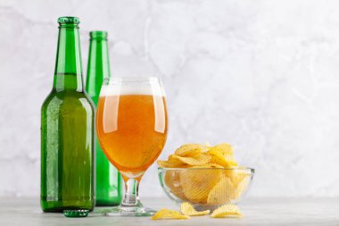 Bira bardağı, bira şişeleri ve patates cipsi. Kopyalama alanı ile