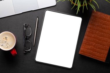 Boş ekranlı tablet ve masa başında ofis malzemeleri. Üst görünüm düzlüğü kopyalama alanı ile yatıyordu