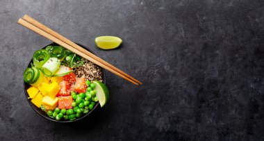 Somon, salatalık ve mango dolu bir kase. Geleneksel Hawaii yemeği. Üst görünüm düzlüğü kopyalama alanı ile yatıyordu