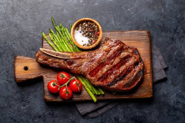 Orta pişmiş Tomahawk bifteği ve kuşkonmaz. Düz yatıyordu