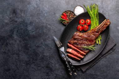 Orta pişmiş Tomahawk bifteği ve kuşkonmaz. Kopyalama alanı olan düz