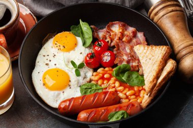 Yağda yumurta, fasulye, pastırma ve sosisli İngiliz kahvaltısı. Üst görünüm