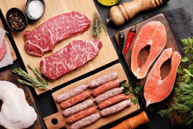 Çeşitli çiğ et ve balıklar. Biftek, sosis, somon, tavuk ve baharat. Düz yatıyordu