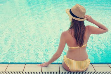 Yüzme havuzunda rahatlatıcı genç çekici kadın. Metniniz için kopya alanı. Güneşli tonlu