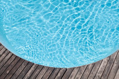 Havuz başı ahşap güvertesi ve mavi havuz suyu. Üst görünüm düzlüğü kopyalama alanı ile yatıyordu