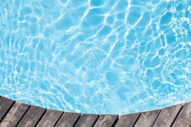 Havuz başı ahşap güvertesi ve mavi havuz suyu. Üst görünüm düzlüğü kopyalama alanı ile yatıyordu