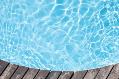 Poolside wooden deck and blue water of pool. Top view flat lay with copy space clipart