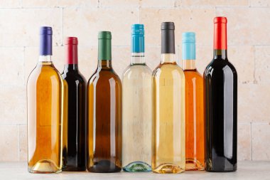 Taş masada çeşitli şarap şişeleri var.