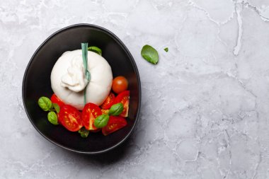Burrata cheese, cherry tomatoes and basil. Italian cuisine. Flat lay with copy space