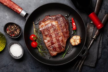 Kızartma tavasında ızgara biftek ve baharat. Düz yatıyordu