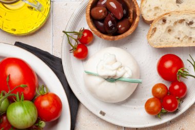 Burrata peyniri, çeşitli domatesler ve zeytinler. İtalyan mutfağı. Düz yatıyordu
