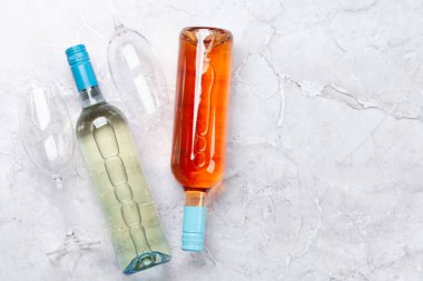 Various wine bottles and glasses on stone table. Flat lay with copy space