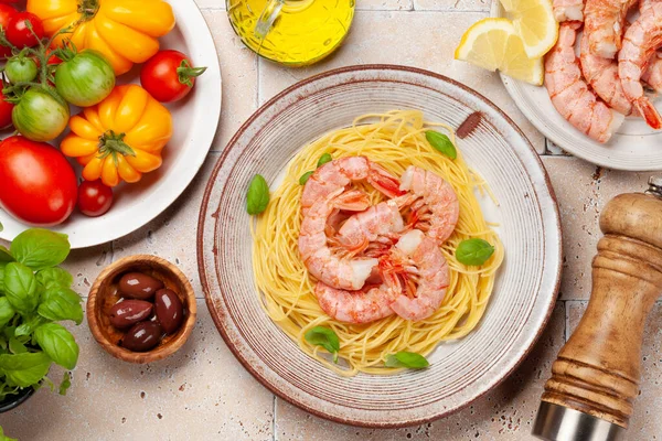 Pasta with shrimps and various garden tomatoes. Italian cuisine. Flat lay