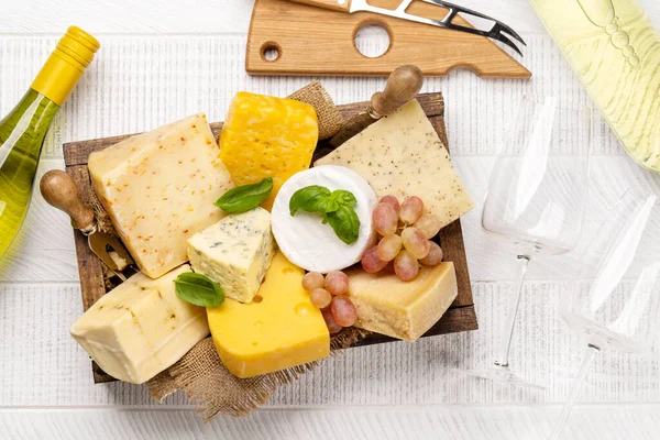 ボード上の様々なチーズと白ワイン — ストック写真