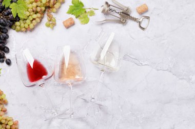 Beyaz, gül, kırmızı şarap kadehi ve üzüm. Kopyalama alanı olan düz