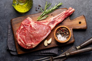 Çiğ Tomahawk bifteği ve baharatları. Izgara için hazırız. Düz yatıyordu