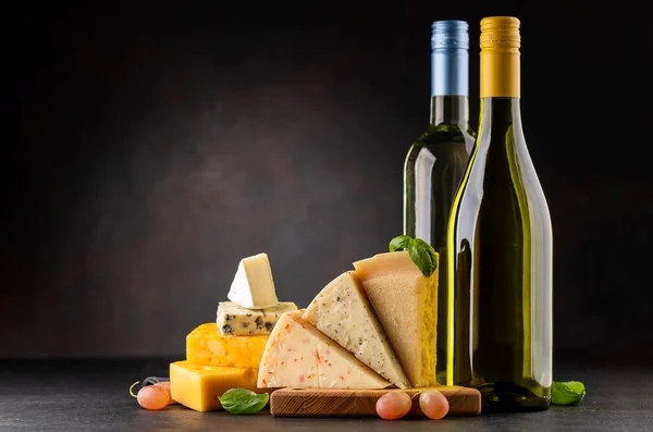 ボード上の様々なチーズと白ワイン 暗い背景の上にコピースペース — ストック写真