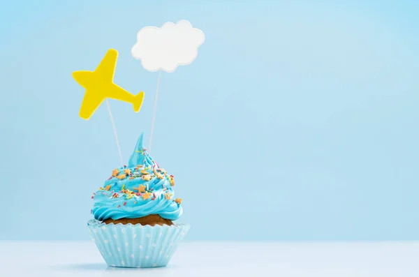 Blue cream cupcake with decor on blue background with copy space