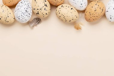 Easter eggs on a beige background with space for your greetings. Flat lay