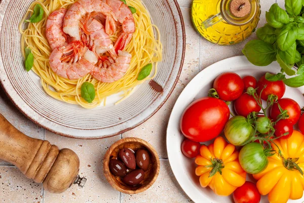 Pasta with shrimps and various garden tomatoes. Italian cuisine. Flat lay