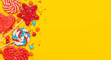 Various candy sweets on yellow background and copy space for your text. Flat lay