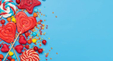 Various candy sweets on blue background and copy space for your text. Flat lay