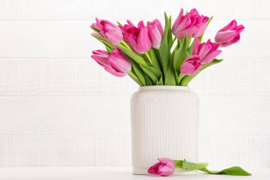 Fresh pink tulip flowers bouquet. On white wooden table with copy space
