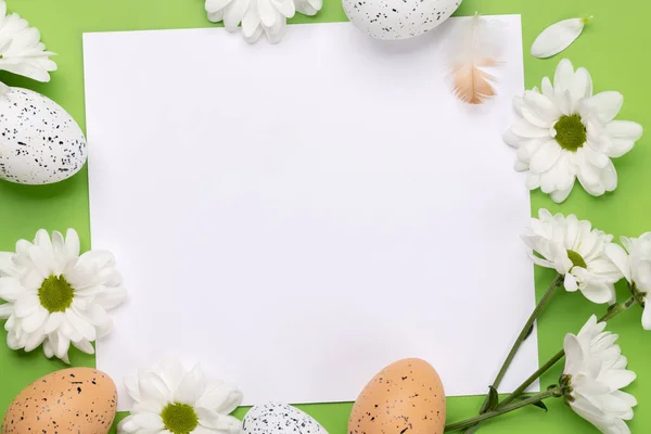 挨拶のために白いカードで緑の背景にイースターエッグと花 — ストック写真