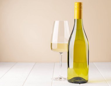 White wine bottle and glass on wooden table with copy space